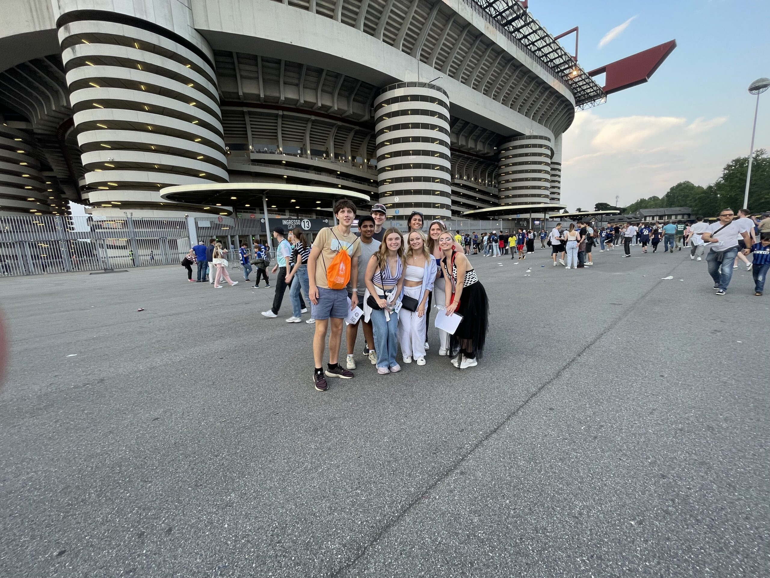 Emma posing with friends in front of the Milan soccer stadium.