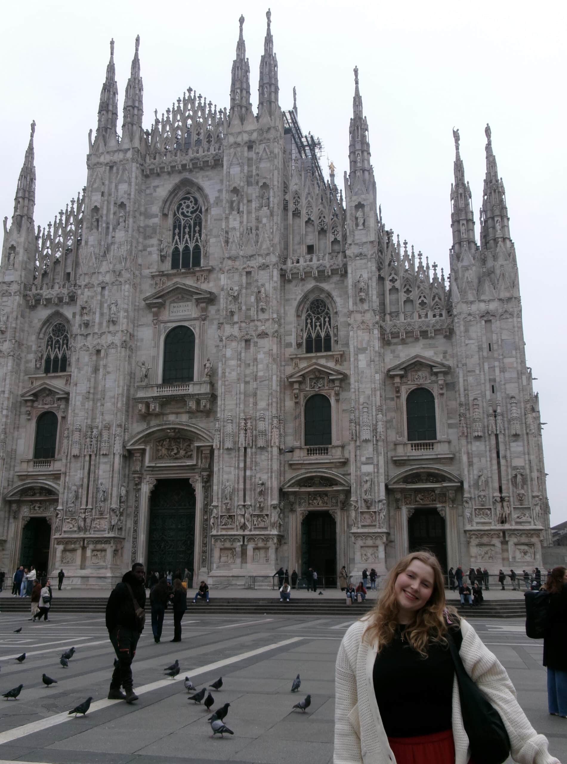 Girl posing in front of an impressive buildling