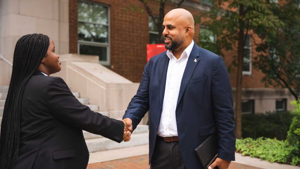 One female and one male shake hands