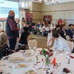 one male speaking to luncheon audience