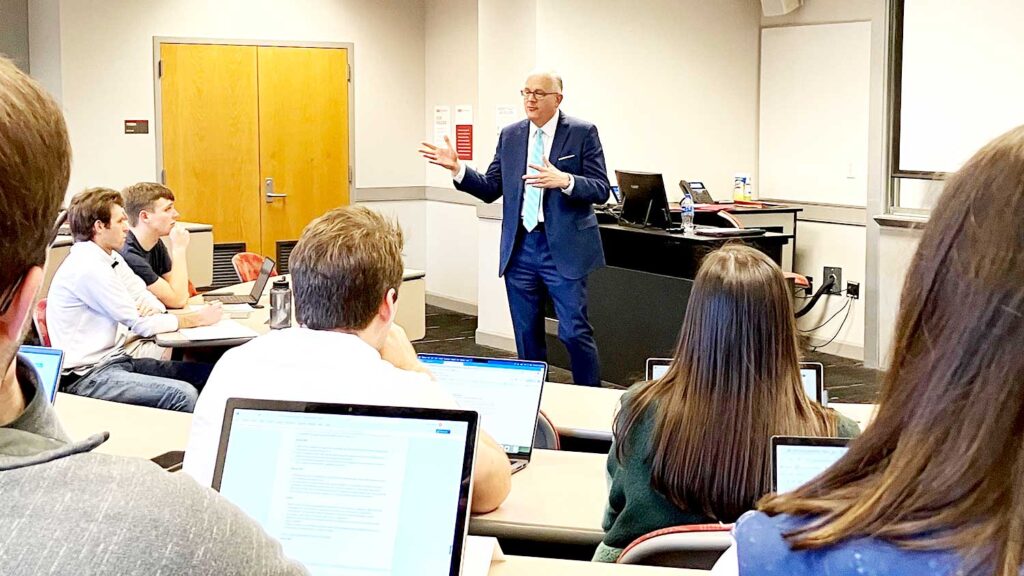 male professor with male and female college students