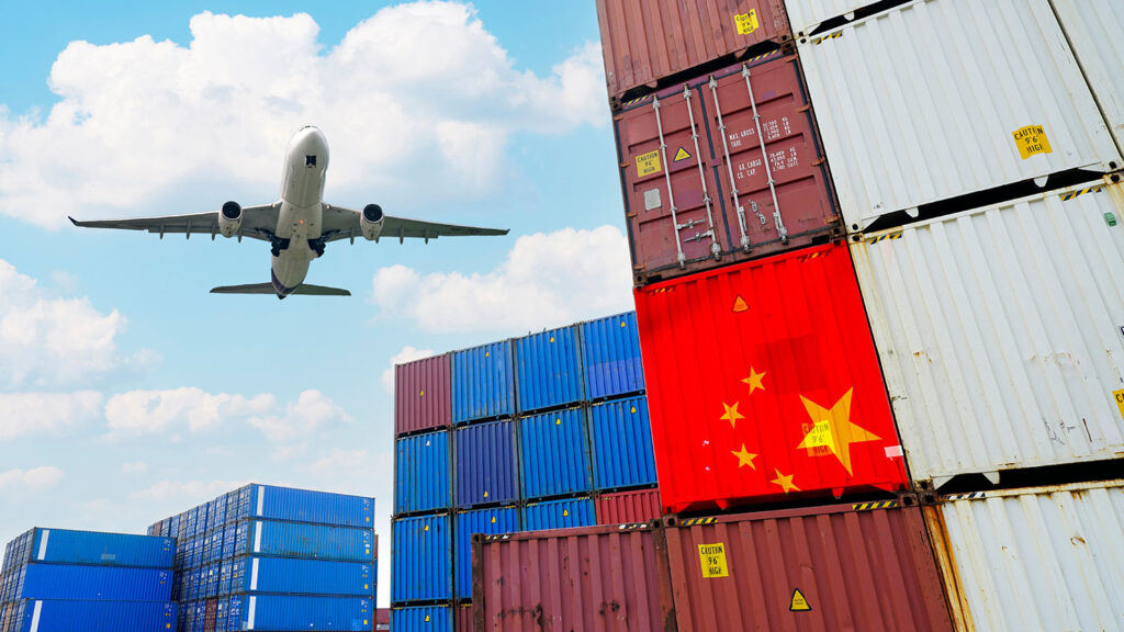 plane flying over cargo ship containers