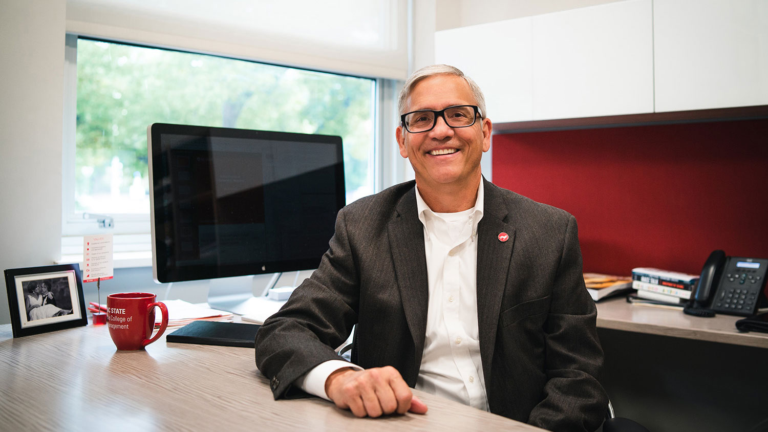 Poole College Dean Frank Buckless sitting at his desk