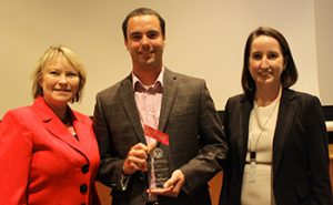 Allan Autry and Lauren Williams, with Johnson Lambert, accept the Poole College Employer of the Year Award from Annette L. Ranft, Stephen P. Zelnak Jr. chair and dean of Poole College.