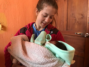 Poole Alumna Anna Brown with an infant during a Curamericas service trip. Photo provided by Curamericas.