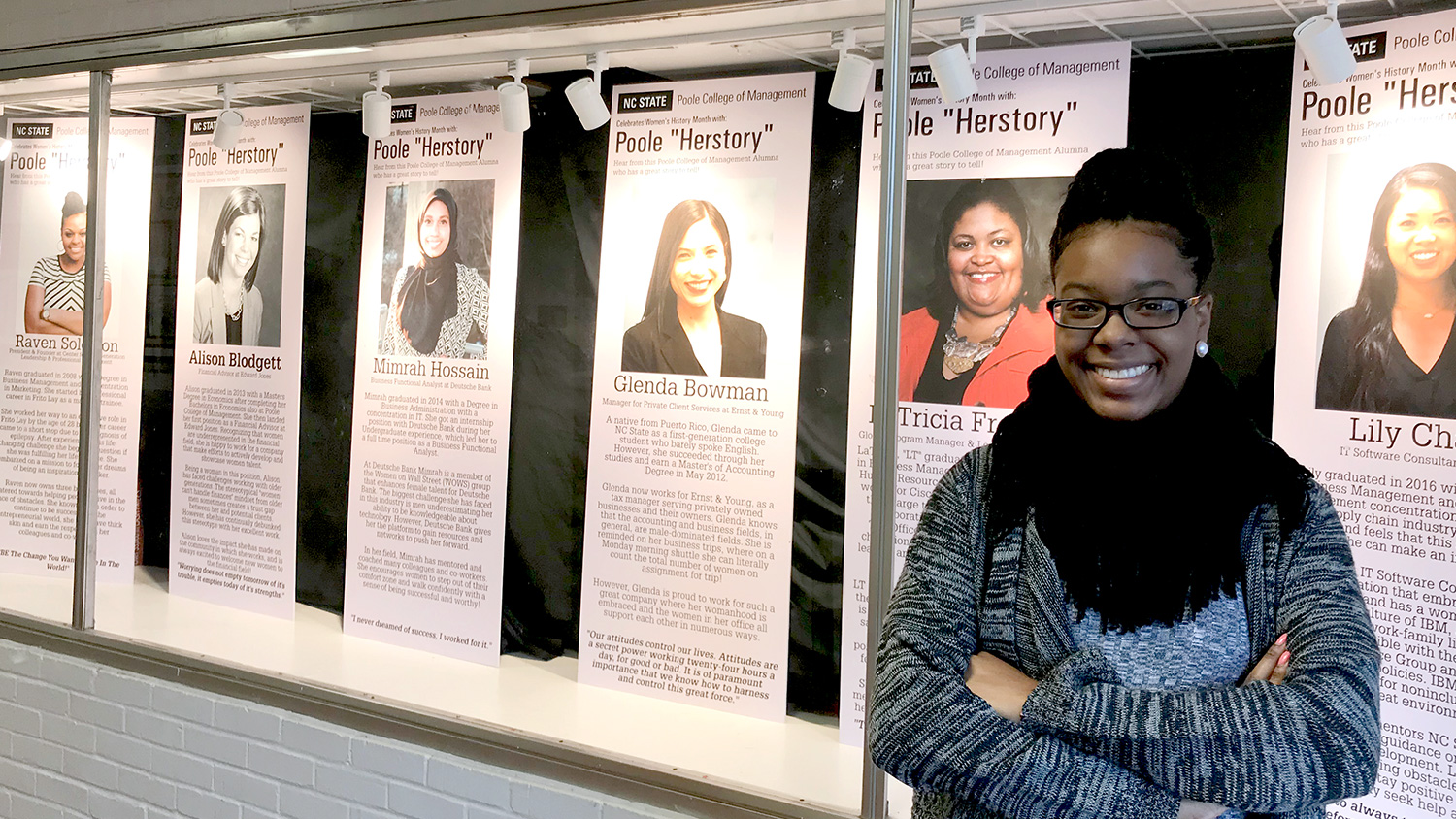 Jessica Carter with the Herstory display she created, featuring Poole College alumnae; it is in Nelson Hall's third floor exhibit space.