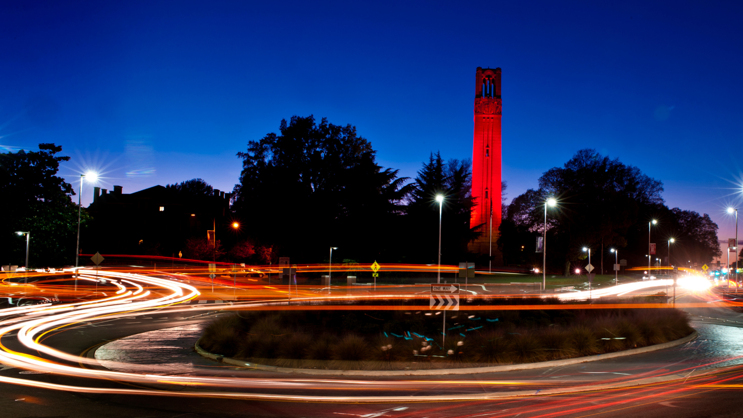 NC State Memorial Bell tower lit red at night
