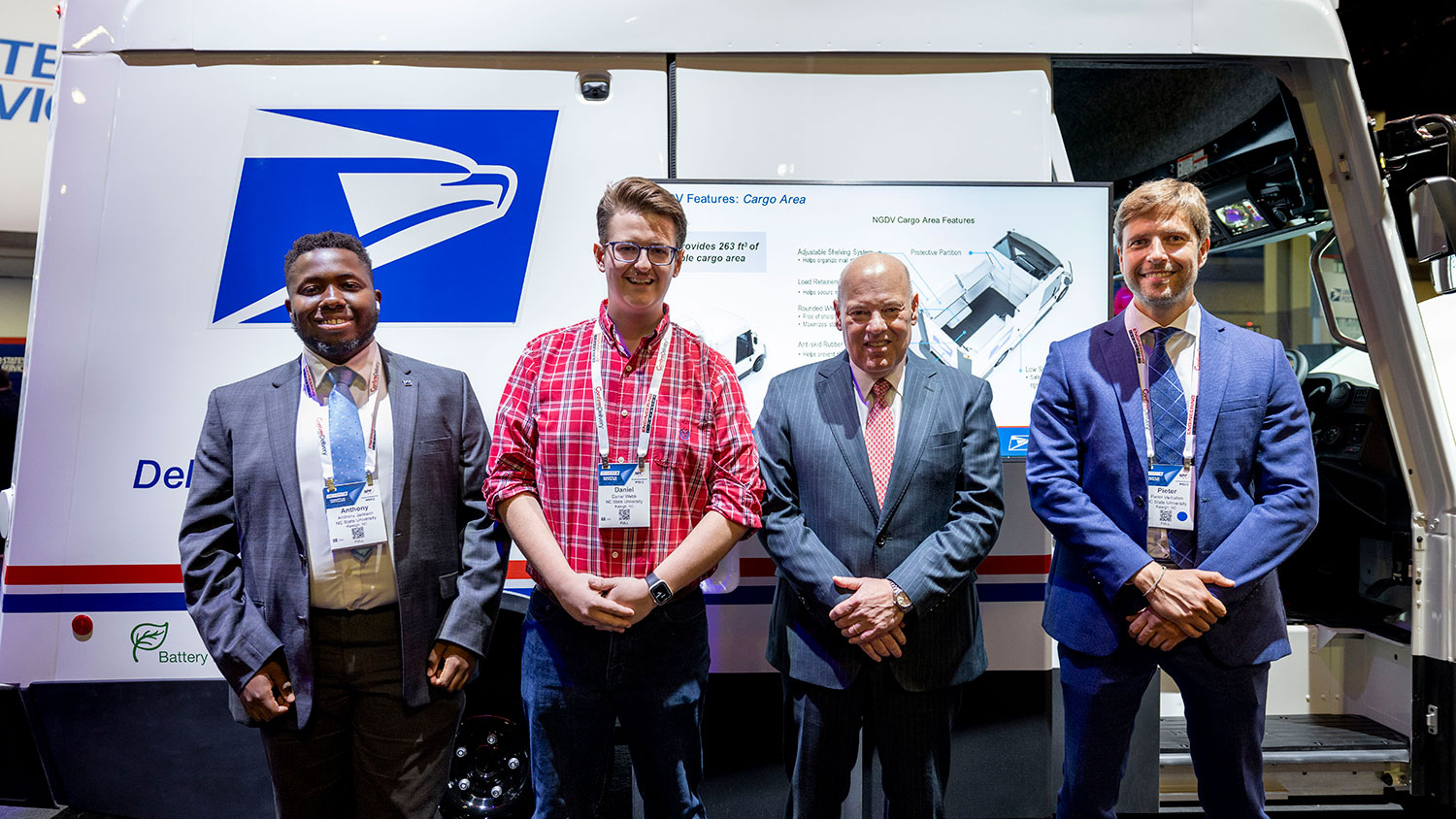 Pictured left to right are recent Poole graduates Anthony Jackson and Daniel Webb, USPS Postmaster General Louis DeJoy, and Pieter Verhallen, teaching assistant professor in marketing, at the 2023 National Postal Forum in Charlotte, North Carolina.