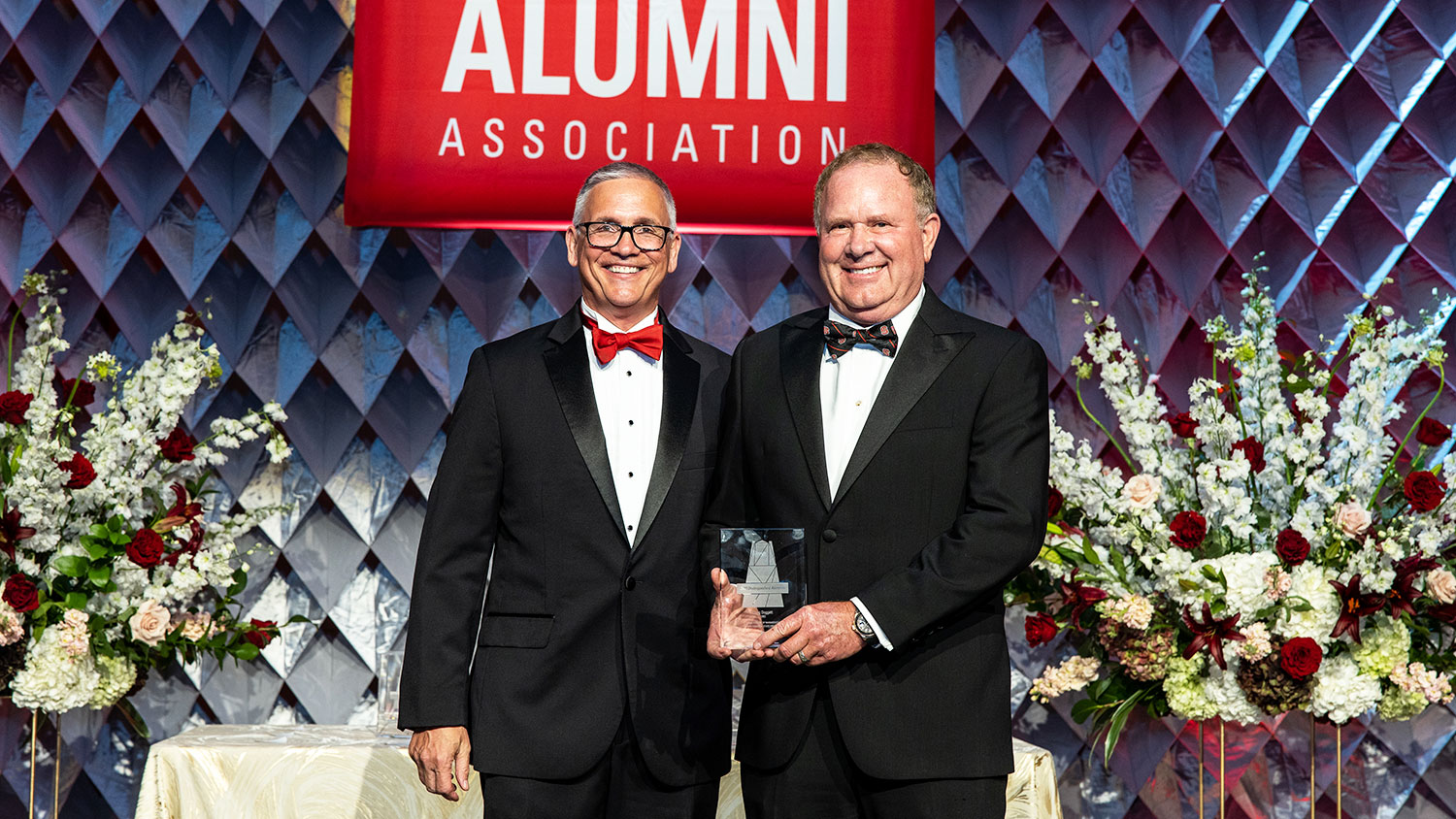Doug Doggett receives the Distinguished Alumni Award from Poole College Dean Frank Buckless.