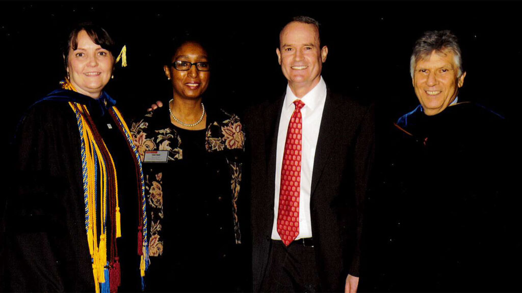 Terry Price (center) with Andy Nowel (right) and a student marshal (left) at the college's spring 2003 ceremony. 