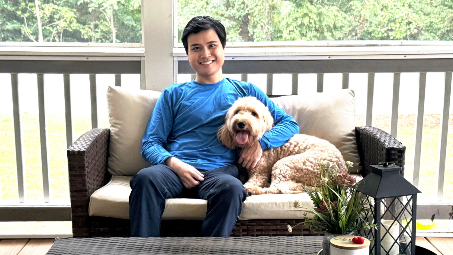 Travis Nguyen sits with a dog