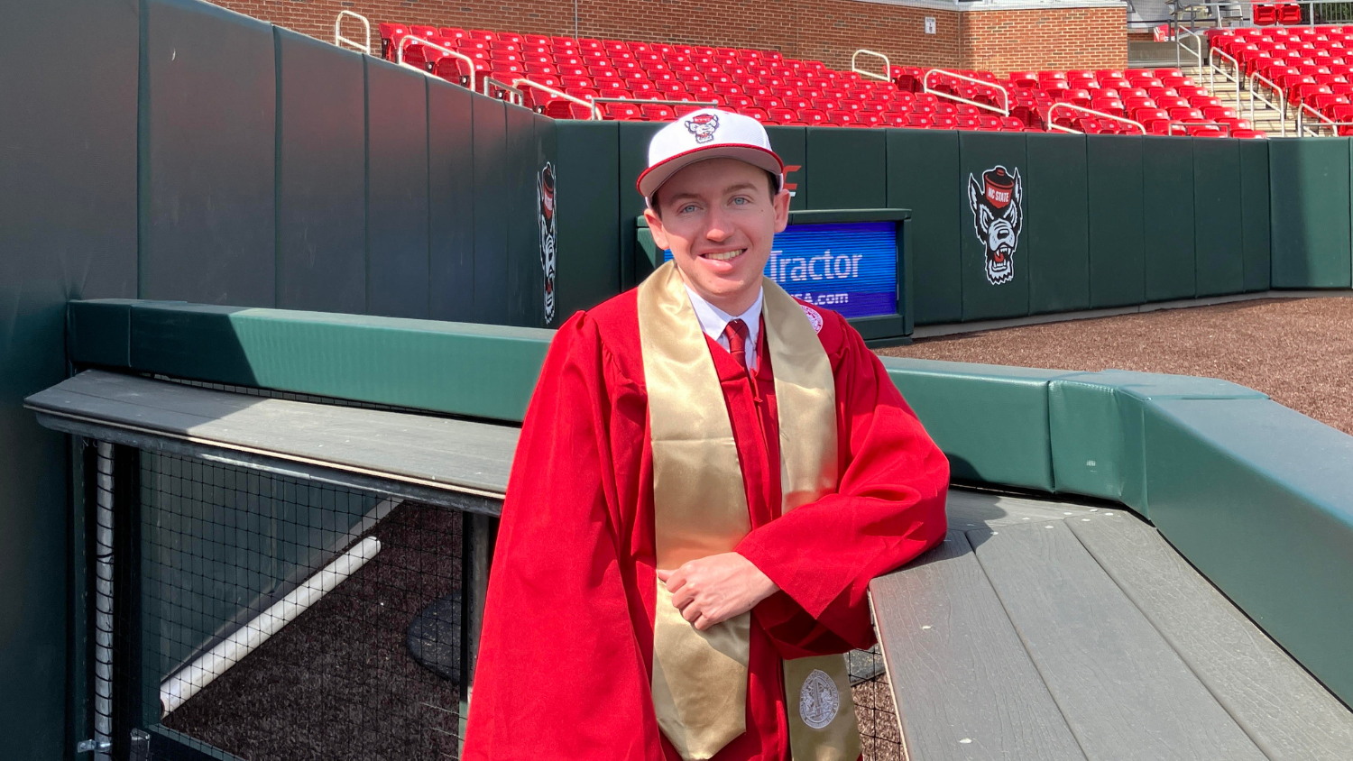 Tucker Parrish wears his cap and gown inside Doak Field