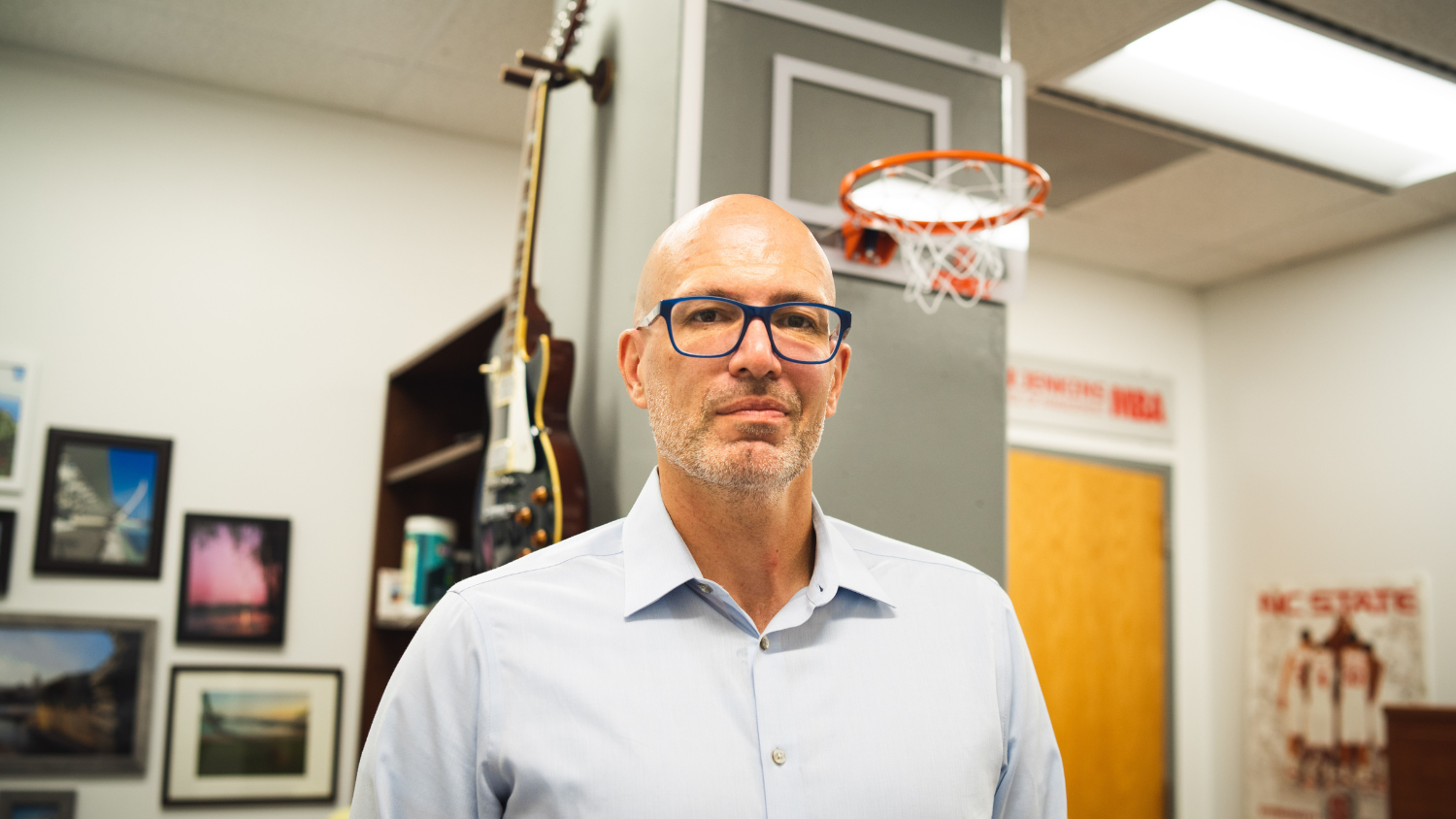Mike Stanko stands in front of a guitar and basketball hoop