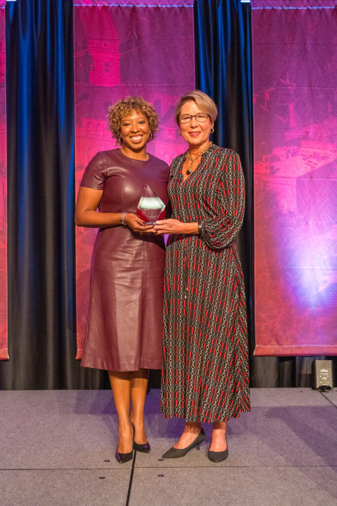 two women posing with an award