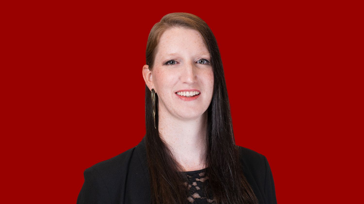 Rebecca Crumpler smiles over red background