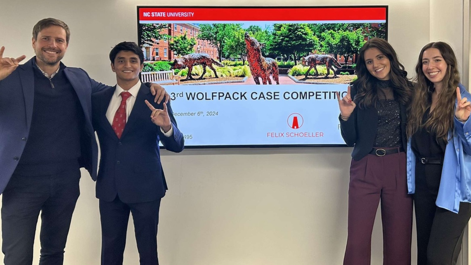 Case competition team making wolfpack sign
