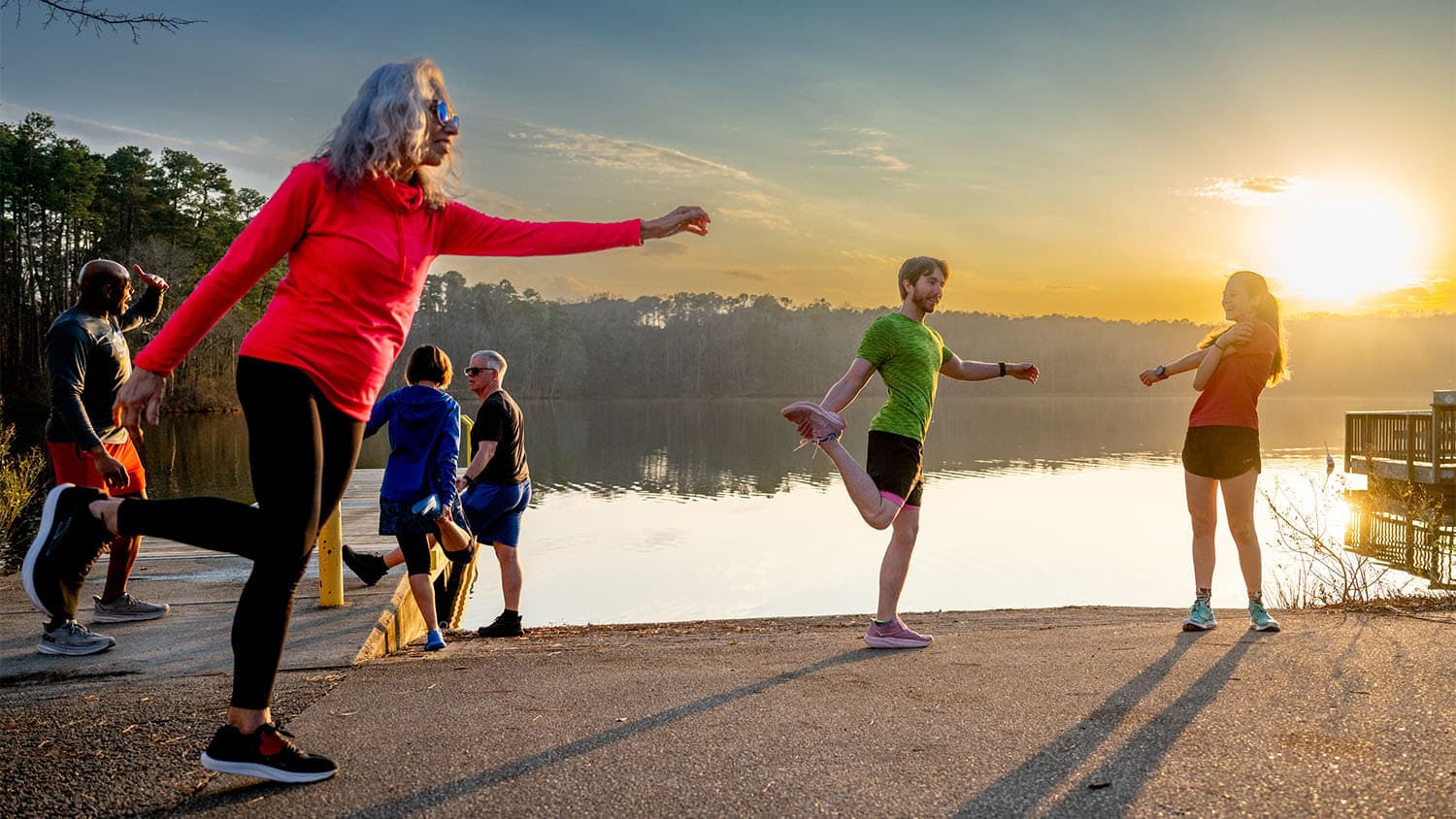 Members of the Wolves on the Run club stretch by Lake Raleigh before hitting the greenway.