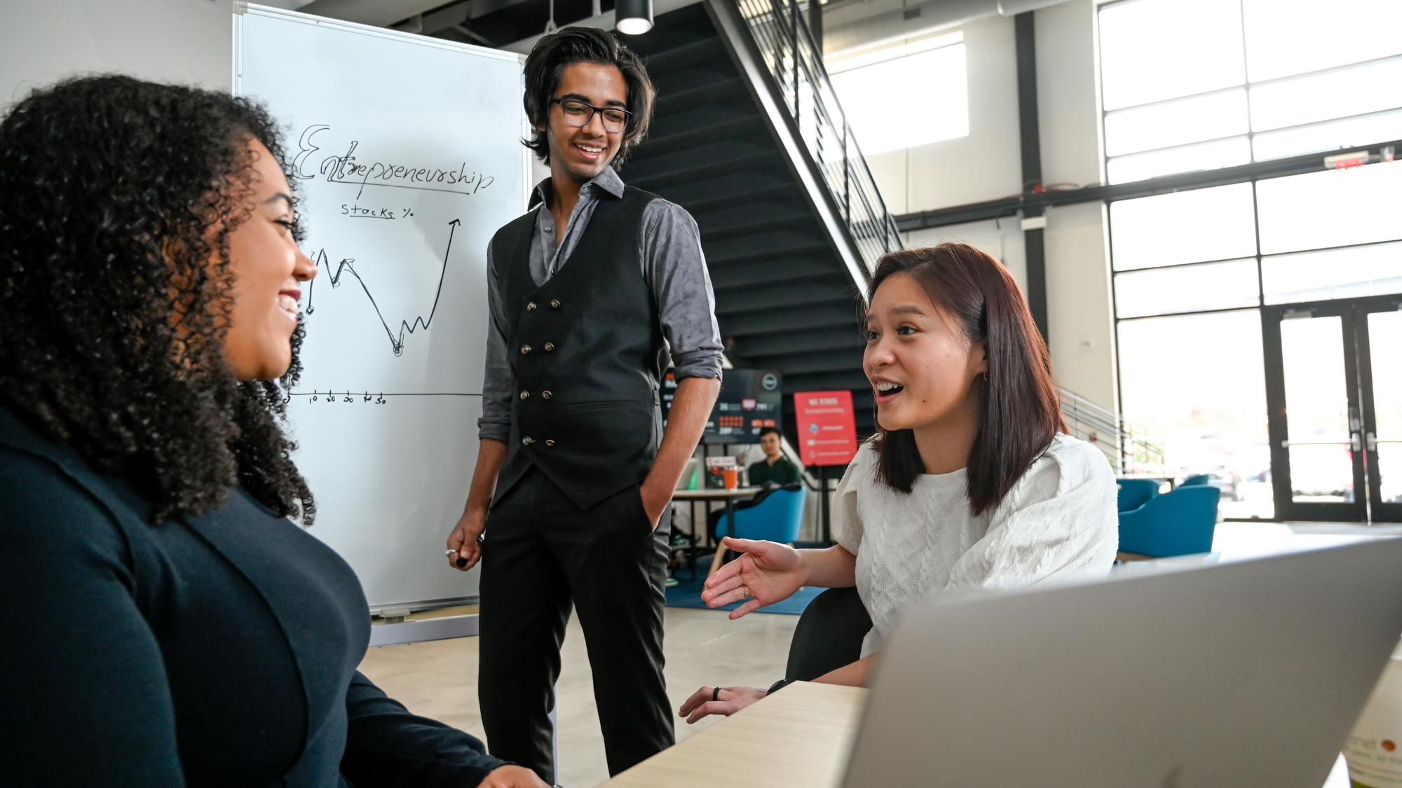 Three students talking and smiling