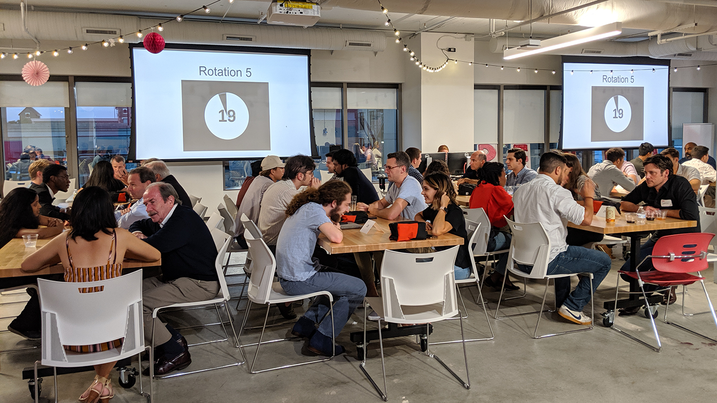 students and mentors sitting around tables
