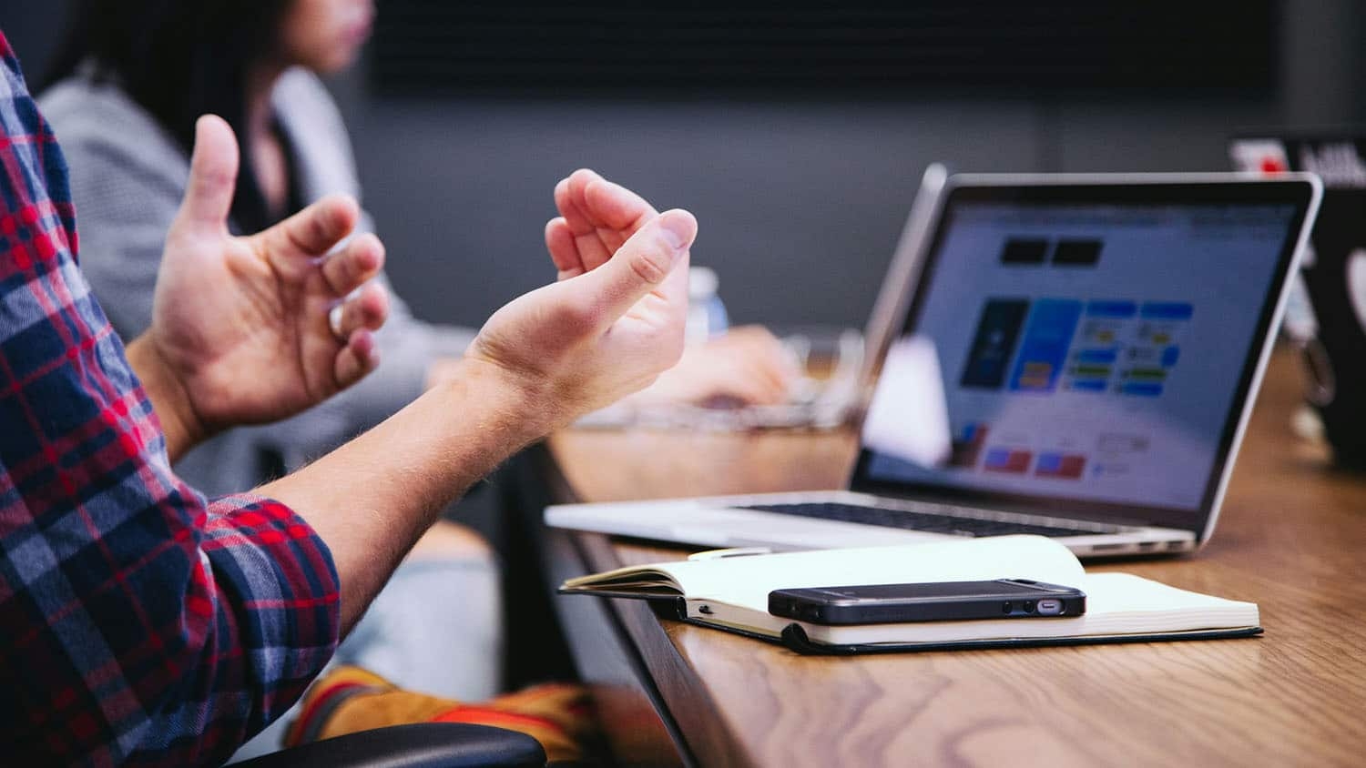 body language suggests two people are debating something around a spreadsheet