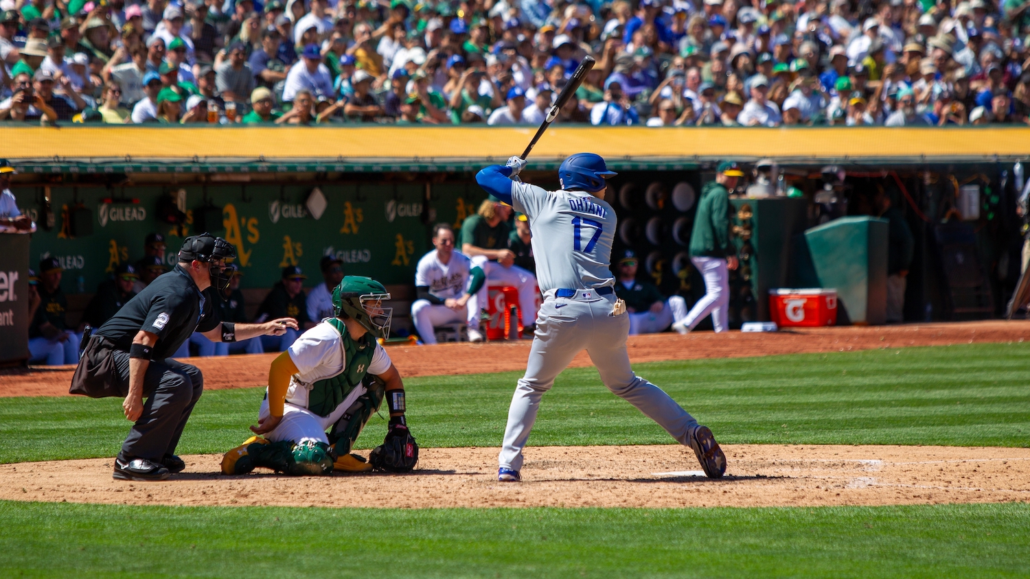 A batter, pitcher and umpire in a baseball game await the pitch.