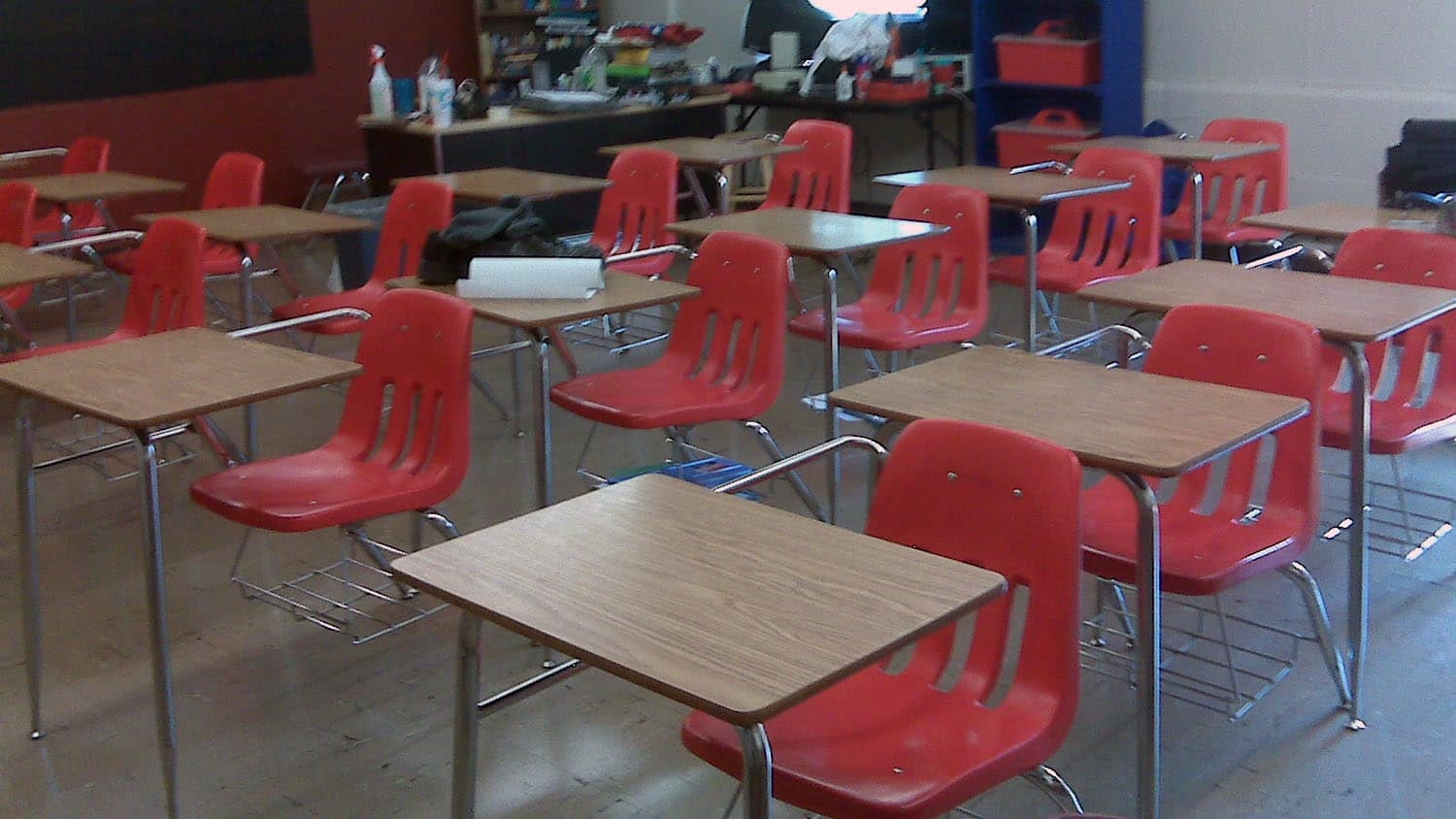 a classroom is filled with empty desks and chairs