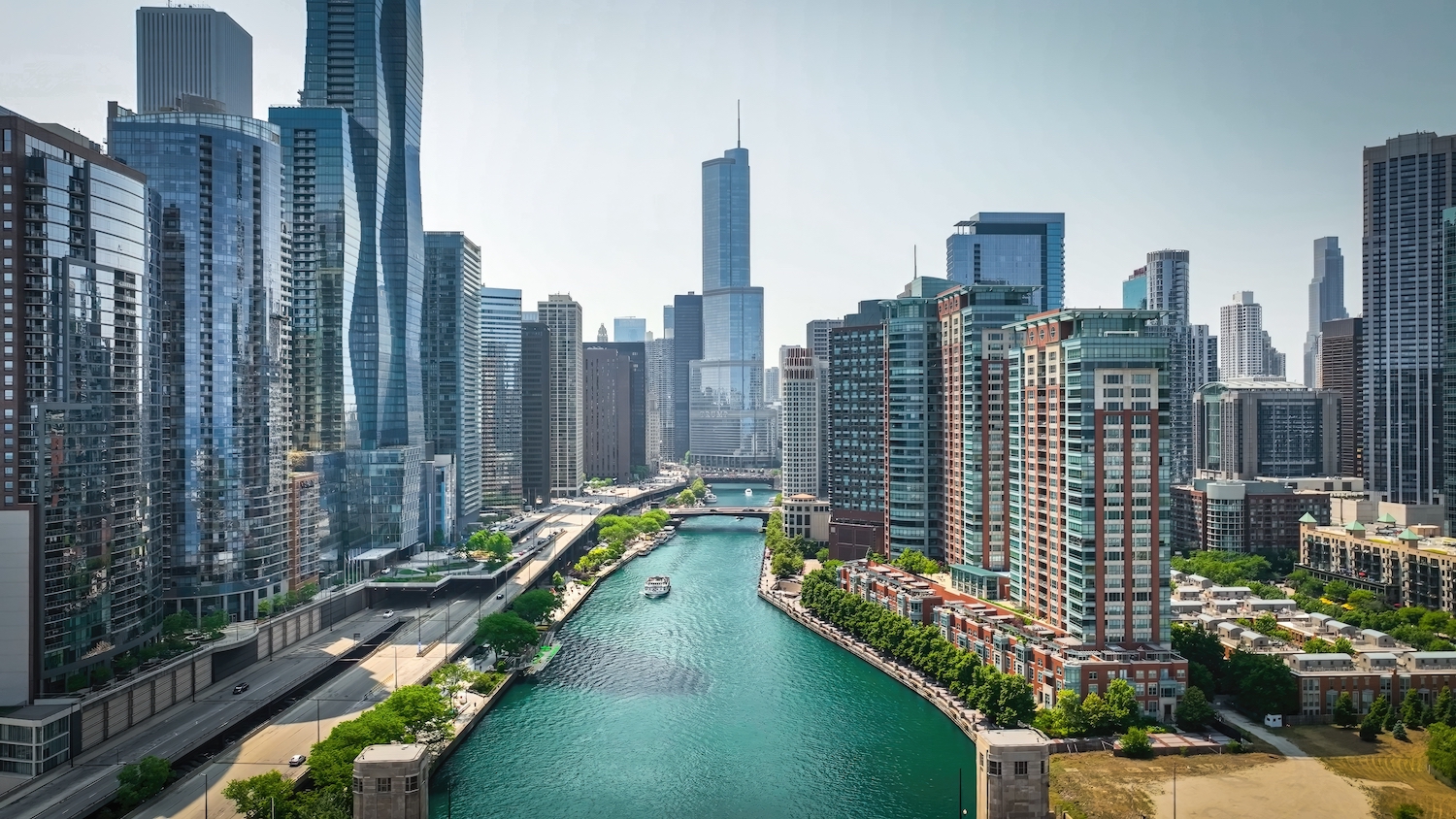 An aerial view of downtown Chicago, with the Chicago River leading to a collection of skyscrapers.