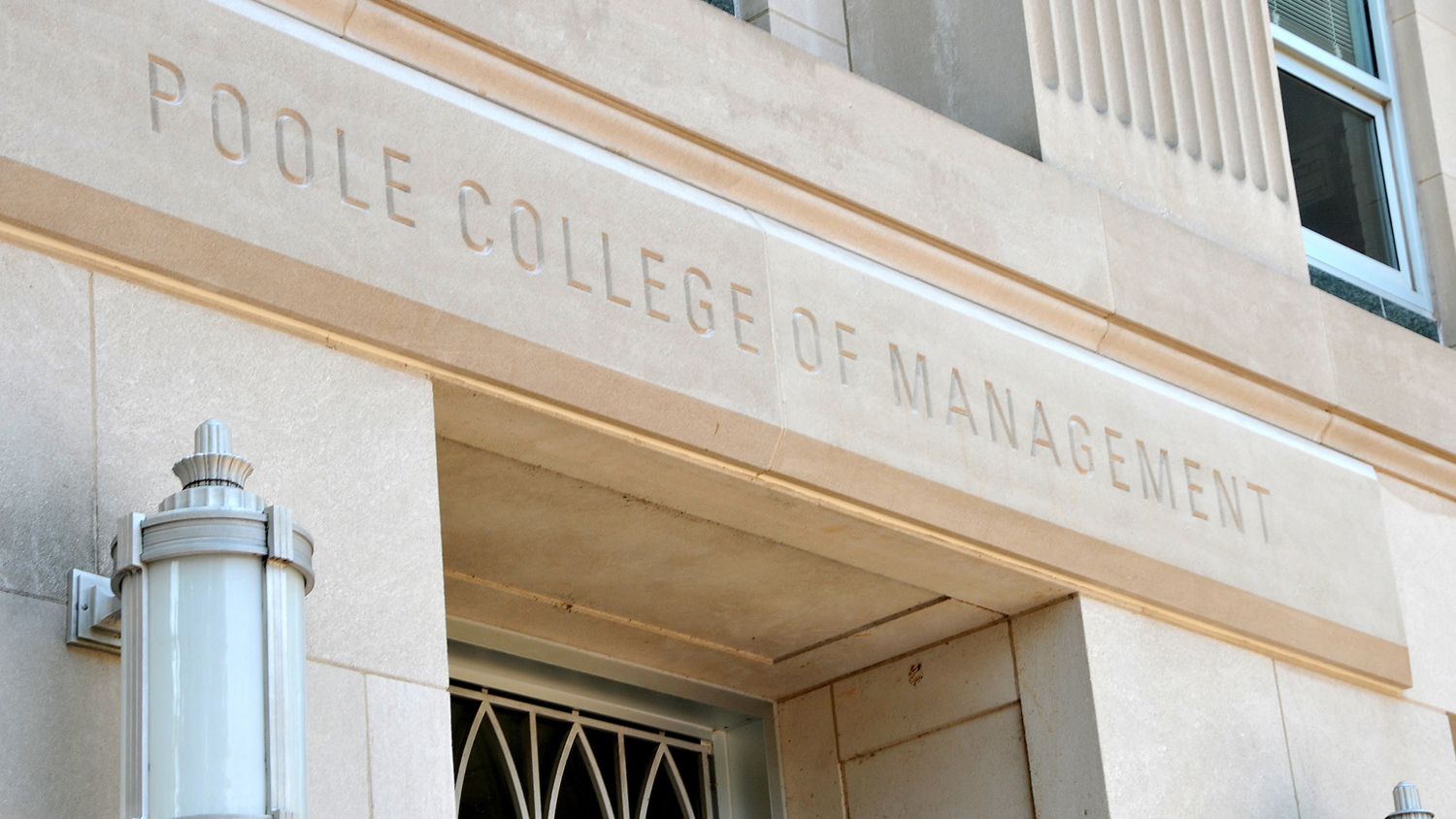 A close-up of the words 'Poole College of Management' engraved on the front of Nelson Hall