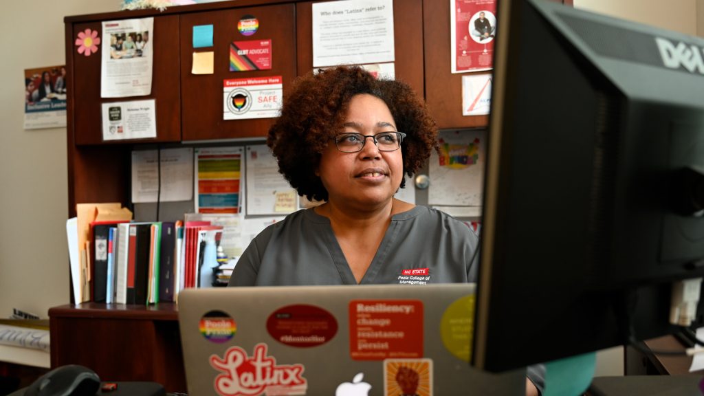 An advisor looks at a computer in her office