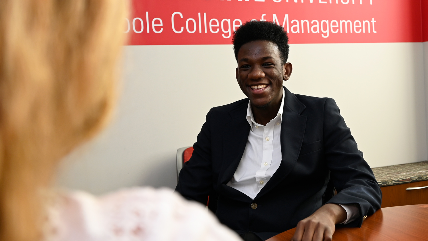 A student smiles while interviewing with a professional