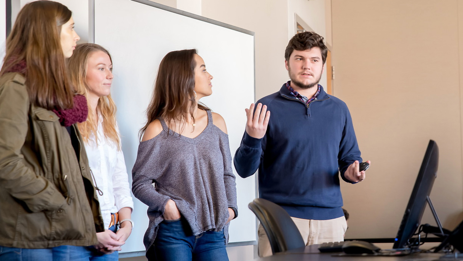 Four students present in front of a classroom