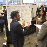 student points at poster