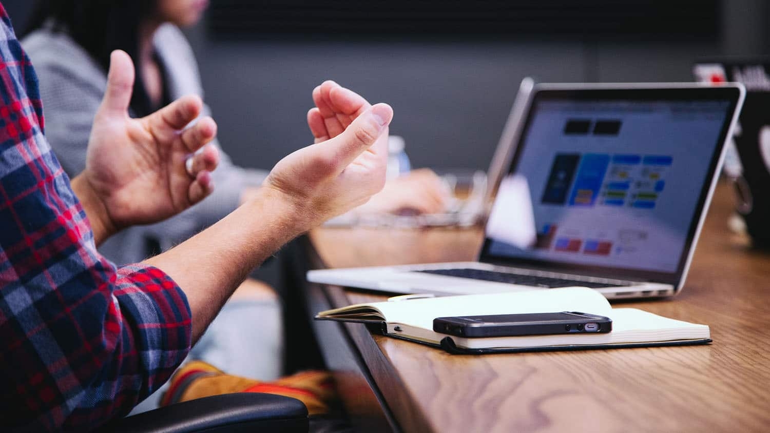 man in a work meeting gestures with hands